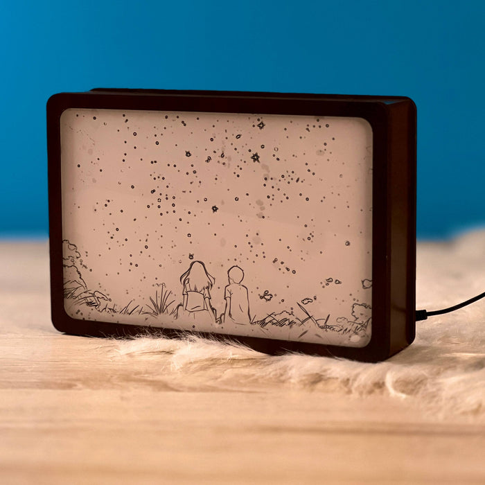 Our Moonlight Night Light Box switched off, engraved couple sitting under a starry sky