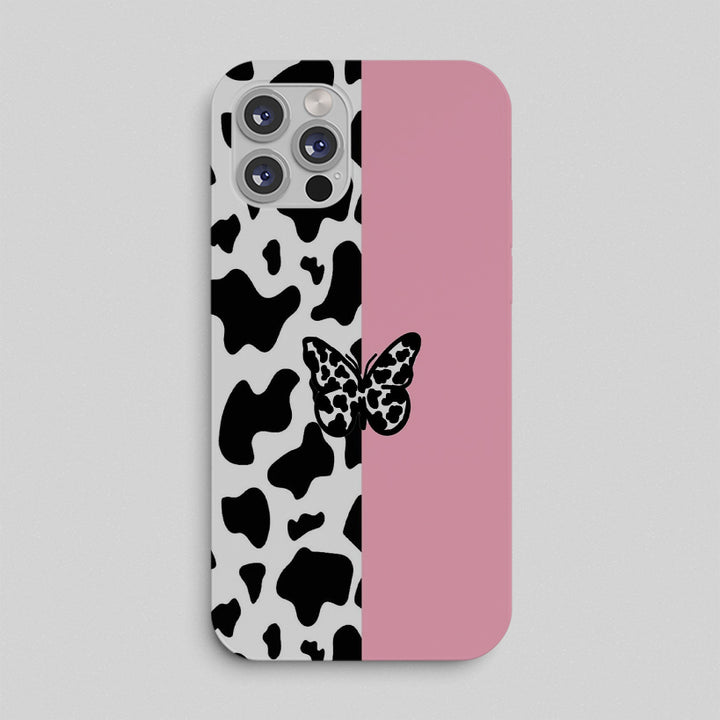 Phone case with cow print and butterfly design on a gray background