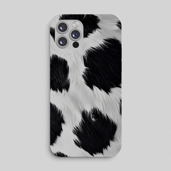 Phone case with black and white cow print pattern on a light gray background