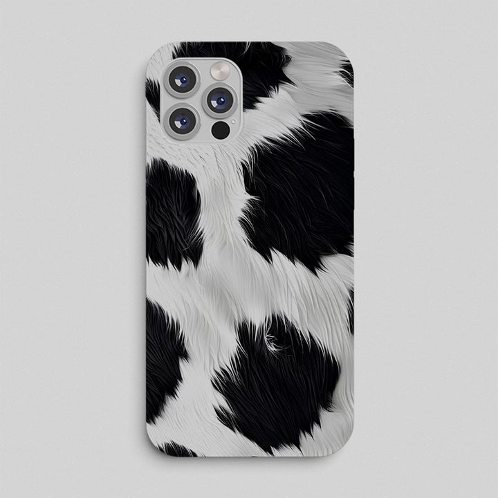 Phone case with black and white cow print pattern on a light gray background