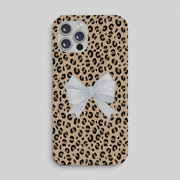 Phone case with leopard print pattern and a white bow on a light gray background