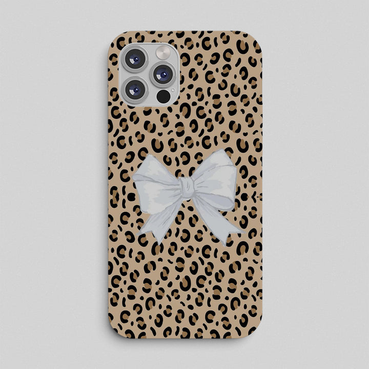 Phone case with leopard print pattern and a white bow on a light gray background