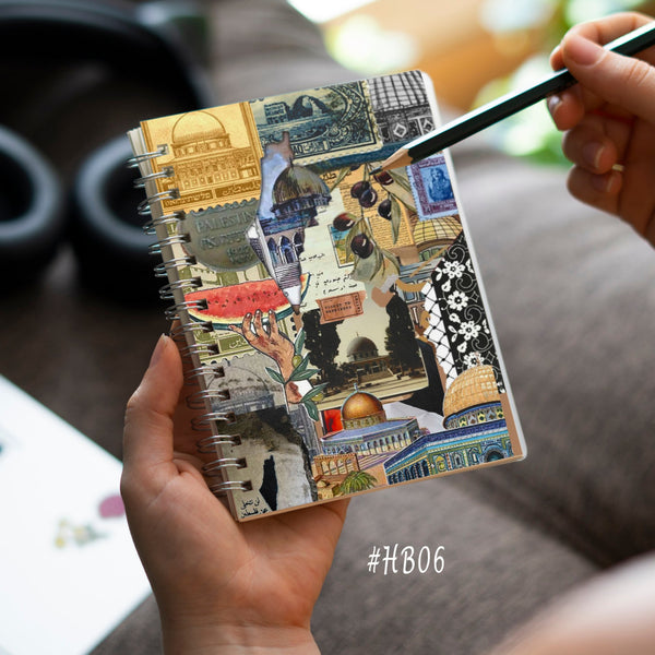 Person holding a notebook with artistic cover design, blurred background