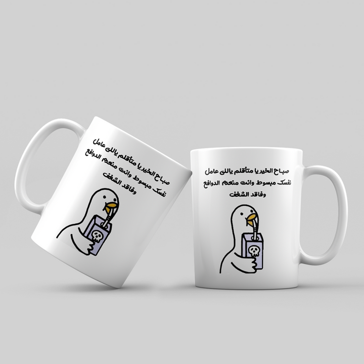 Two white mugs with Arabic text and a graphic of a bird holding a phone on a light gray background.