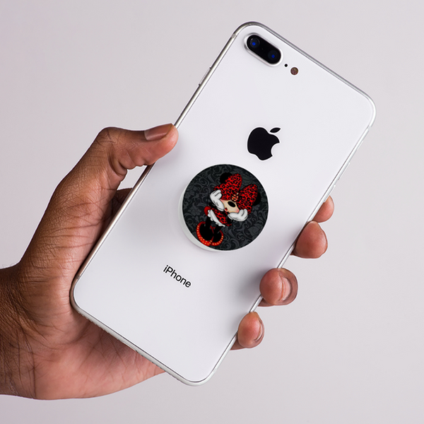 Hand holding a white iPhone with a pop socket featuring Mini mouse disney cartoon character on a light gray background