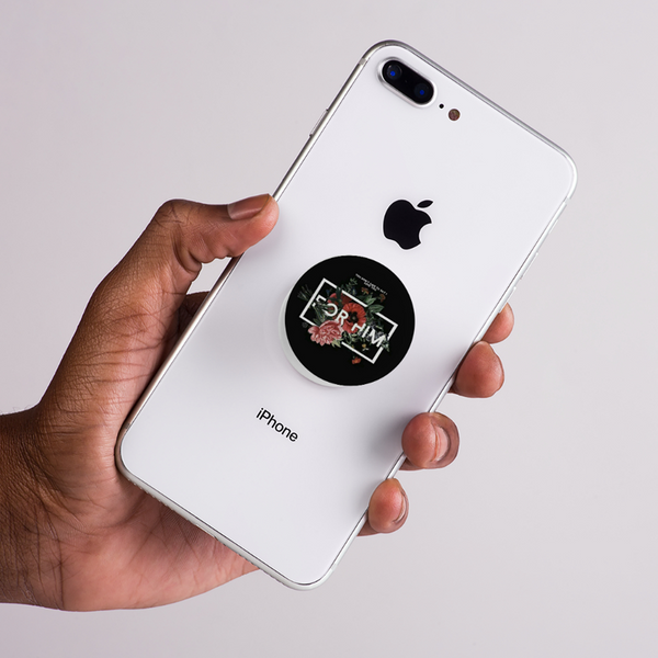 Hand holding a white iPhone with a black pop socket with the quote for him on a light gray background by bunny store