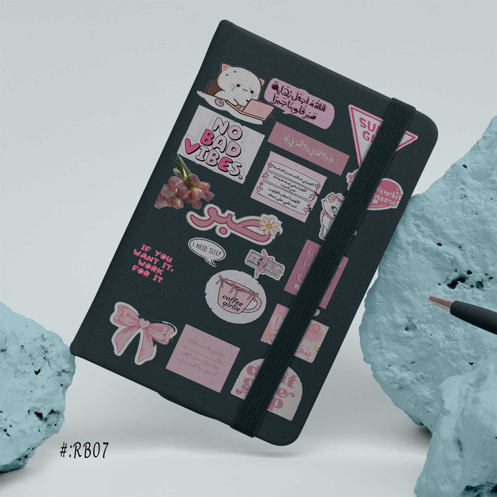 Hardcover notebook with black cover decorated in pink motivational stickers, Arabic and English quotes, and cute graphics