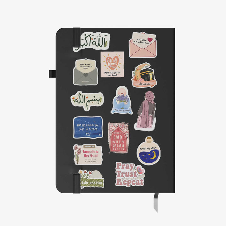 Hardcover notebook with black cover decorated in Islamic motivational stickers, Arabic quotes, and faith-inspired graphics