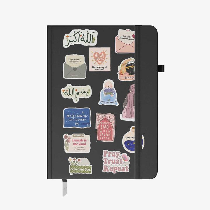 Hardcover notebook with black cover decorated in Islamic motivational stickers, Arabic quotes, and faith-inspired graphics