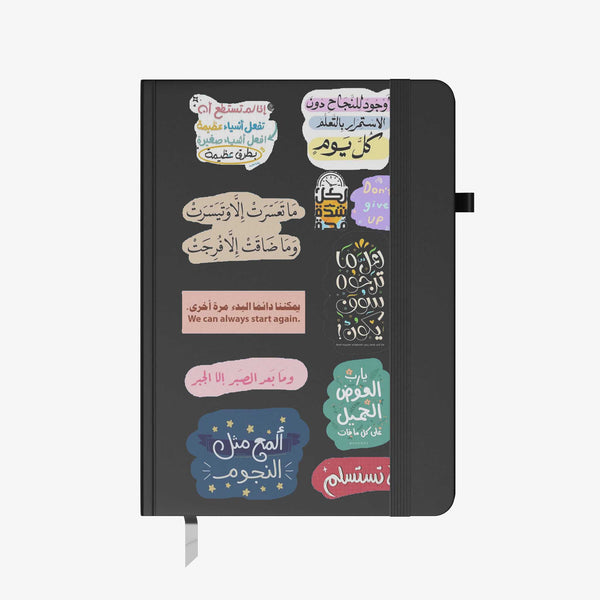 Hardcover notebook with black cover decorated in colorful Arabic motivational quote stickers